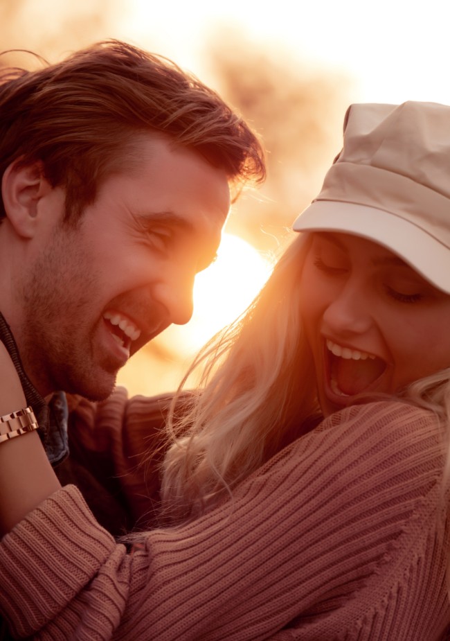 Couple embracing in front of sunset