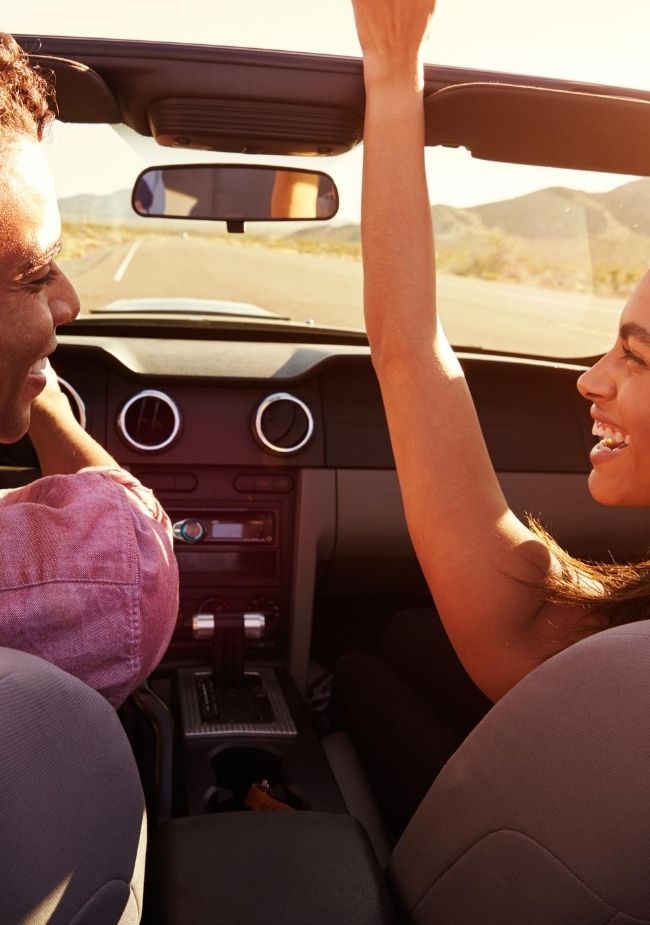 Couple enjoying a ride in a convertible